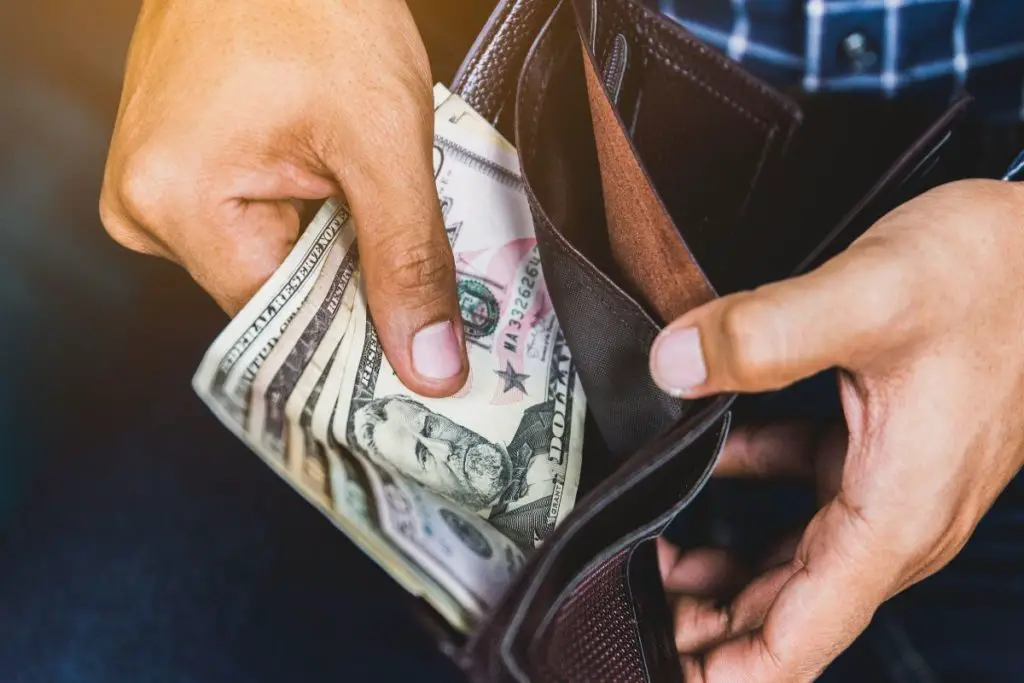 Man opening his wallet with money in it