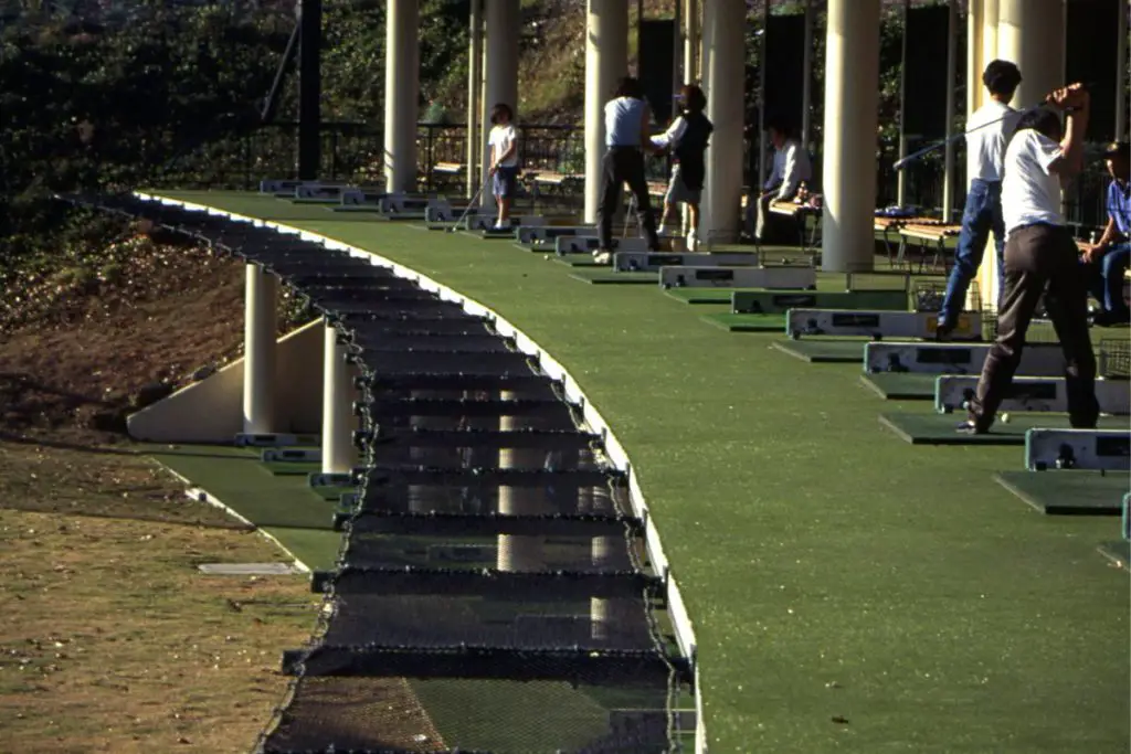 People golfing at a driving range