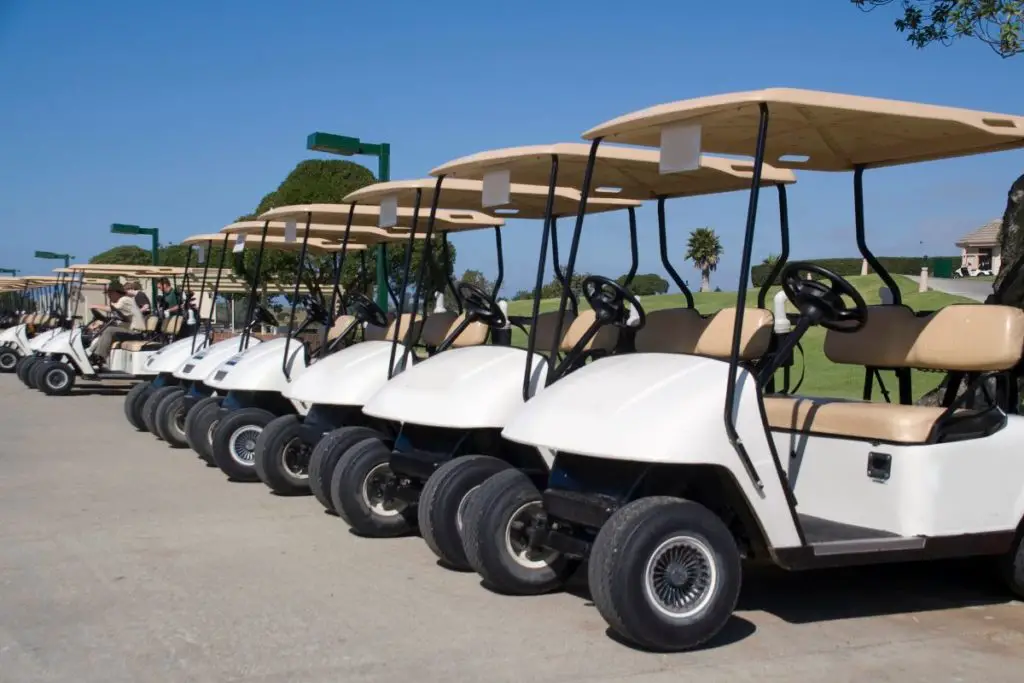 Used golf carts sitting in a parking lot